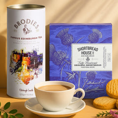 Shortbread House of Edinburgh Original shortbread package alongside a cup of tea on a wooden table