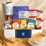 Hamper contents neatly arranged inside a gift box: tea drum, shortbread, mini rounds, and assorted biscuits.