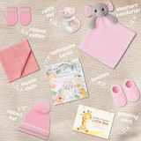Flat lay image of all baby girl hamper contents – hat, mittens, booties, muslin cloth, toy, comforter, and milestone cards neatly arranged
