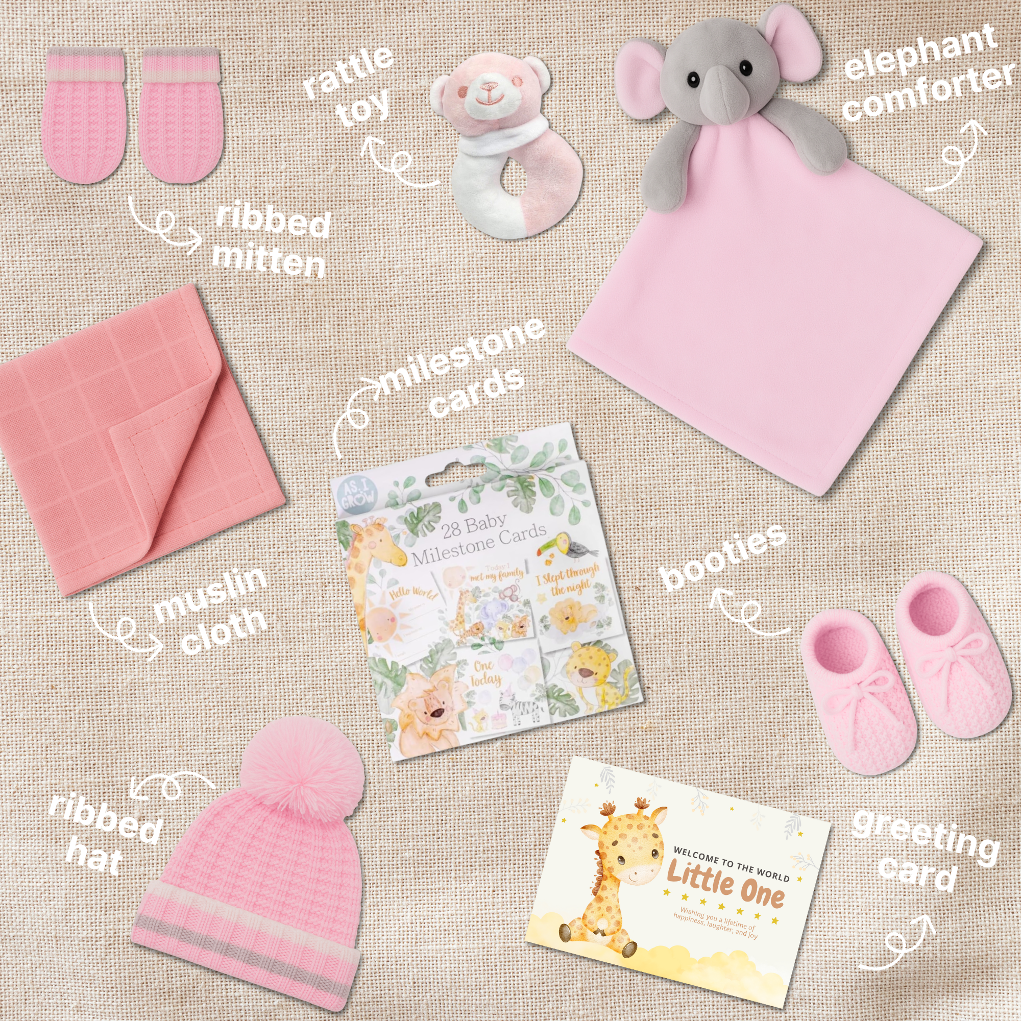 Flat lay image of all baby girl hamper contents – hat, mittens, booties, muslin cloth, toy, comforter, and milestone cards neatly arranged